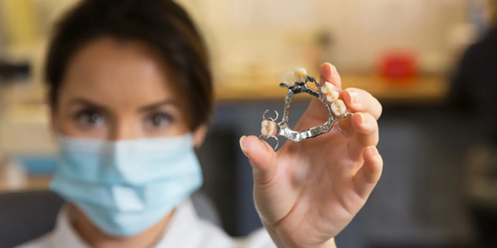 Dental technician holding a chrome partial denture framework at Chrome Cast Dental Laboratory Crowborough